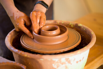 Man potter work with clay ware. Young handsome man potter on his workshop. 