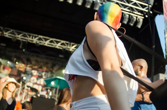 bald woman with a rainbow painted on her head dancing on a gay party