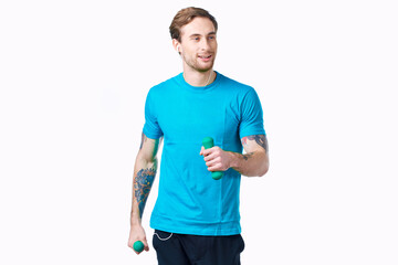 Fototapeta premium handsome sporty man holding dumbbells fitness exercise light background