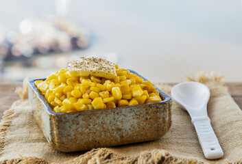 Fried sweet corn with a knob of butter and seasonings Sprinkle with ground black pepper in ceramic...