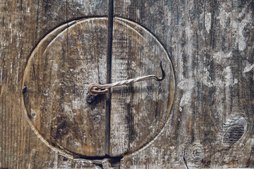 Old gate latch on a weathered wooden door. Beautiful texture and marks 