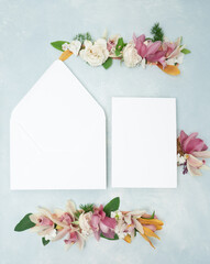 Beautiful bridal stationery flat lay with fresh orchid and rose flowers