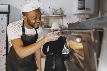 African merican man baking pizza at commercial kitchen