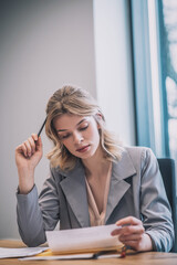 Focused woman reading checking document in office