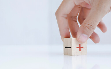 Hand chooses negative to Positive icon on the wood cube, Changing the point of view positive Thinking concept.