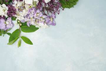Beautiful fresh flower flat lay on light blue textured background with copy space