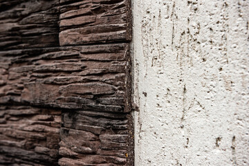 Facade stucco. Wall of house with self-made plastered facade and dark decorative torn brick.