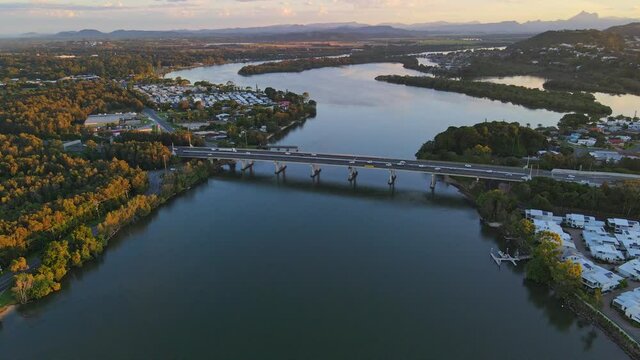 Traffic At Pacific Motorway And Barneys Point Bridge Over Tweed River In Sunset - Lillies Island In Banora Point, NSW, Australia. - aerial