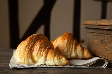 Two fresh french croissants on an old table
