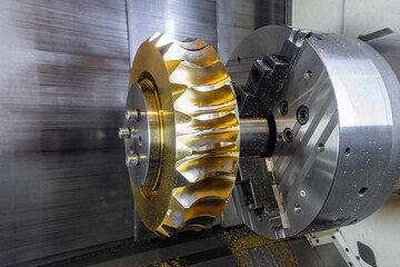 Gear processing on a CNC machine made of bronze, close-up gear cutting production.