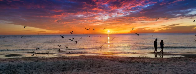 Crédence en verre imprimé Clearwater Beach, Floride Un beau coucher de soleil et une silhouette de couple marchant le long du rivage sur le sable, pris à Clearwater Beach, Floride