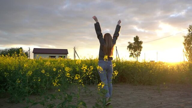 Young girl is practicing yoga outdoors in evening on background beautiful field and sunset. Yoga as a fashion trend in the modern world. Health care, fitness, wellness and lifestyle concept.