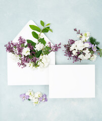 Beautiful floral flat lay with fresh lilac flowers and blank wedding invitation card