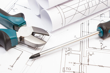 Pliers, screwdriver and diagrams of housing plan with electrical installation. Building home