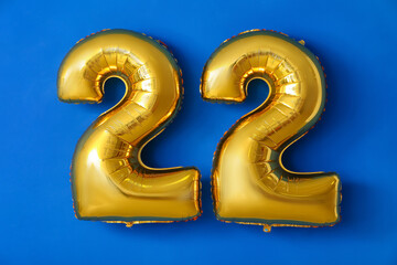 Figure 22 made of balloons on color background