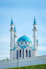 Fototapeta na wymiar Beautiful white mosque with a blue roof against the blue sky.