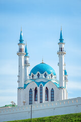 Beautiful white mosque with a blue roof against the blue sky.
