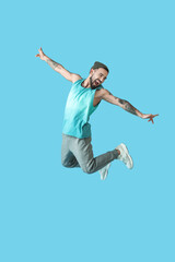 Fototapeta na wymiar Jumping young man on color background