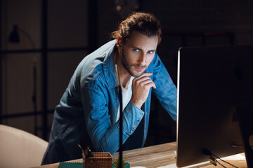 Obraz premium Handsome man working at home late in evening