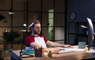 Handsome man working at home late in evening