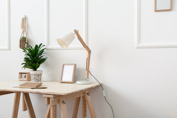 Modern workplace near light wall in room