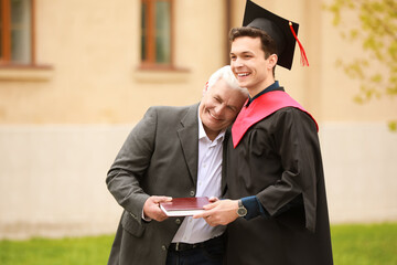 Happy young man with his father on graduation day