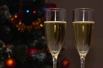 Champagne glasses on the background of a decorated Christmas tree. The concept of a holiday, New Year.