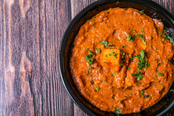 Top shot of Masala Paneer Gravy Indian Cuisine on wooden background