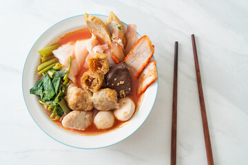 noodles with meatballs in pink soup