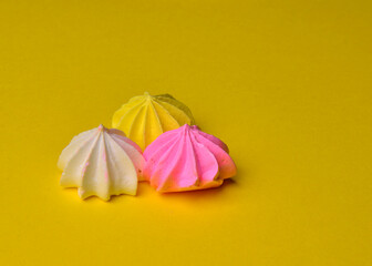 multicolored meringues on a yellow background lie