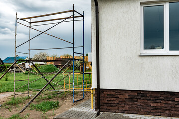 Facade of new house with decorative plaster and torn bricks.