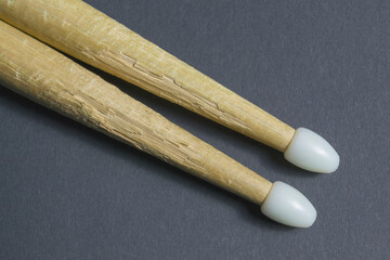 old drum sticks with plastic tips on a gray background are angled to the horizon