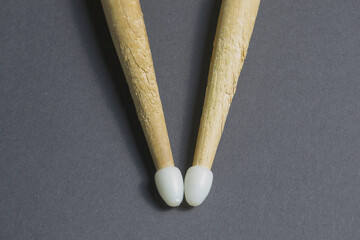 old drum sticks with plastic tips on gray background