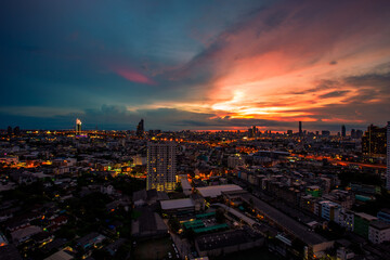 Fototapeta premium The high angle background of the city view with the secret light of the evening, blurring of night lights, showing the distribution of condominiums, dense homes in the capital community