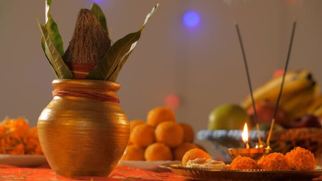 Hindu puja thali and copper Kalash with mango leaves and coconut for worship. Peaceful puja room with different worship items for Diwali prayer during the night - Hindu culture/Indian traditional c...
