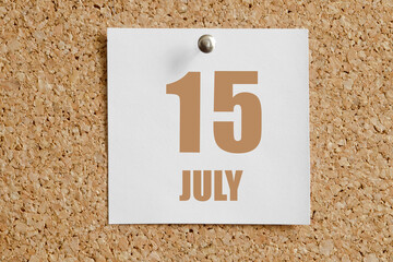 july 15. 15th day of the month, calendar date.White calendar sheet attached to brown cork...