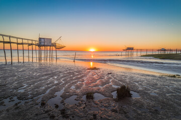 Fishing huts on beach at sunset Atlantic coast of France near La Rochelle