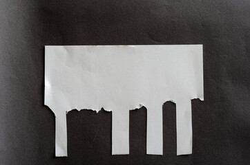 White blank sheet of paper with tear-off tabs on gray background. Crumpled sheet of paper with irregular stripes.