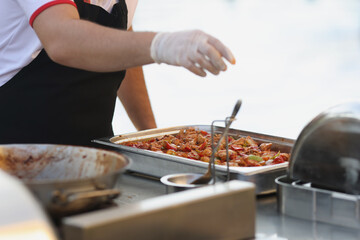 Chef in rubber gloves preparing food in restaurant closeup