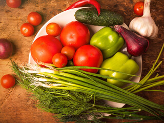 Set of vegetarian products - fresh vegetables with vegetable garden on a rustic wooden background close-up, top view.