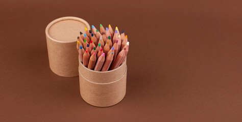 Eco colored pencils made from recycled material. A set of wooden pencils in a box. Top view. Free space for text. High quality photo. Banner . Long format - Powered by Adobe