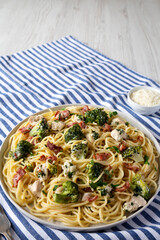 Homemade Chicken Bacon Broccoli Alfredo on a plate, side view. Space for text.