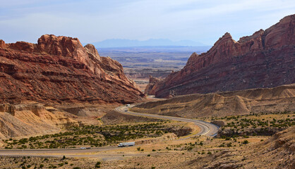 trucks traveling through a pass in the incredible rock formations  of san rafael swell in a very remote part of utah, near green river 