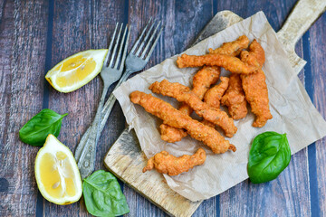 
 Crispy  deep fried home made    chicken strips Breaded  with  almond flour chicken  breast fillets  with chilly peppers and fresh   basil on wooden rustic background. Ketogenic diet food
