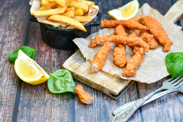 
 Crispy  deep fried home made    chicken strips Breaded  with  almond flour chicken  breast fillets  with chilly peppers and fresh   basil on wooden rustic background. Ketogenic diet food