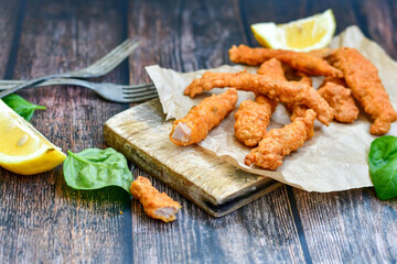
 Crispy  deep fried home made    chicken strips Breaded  with  almond flour chicken  breast fillets  with chilly peppers and fresh   basil on wooden rustic background. Ketogenic diet food