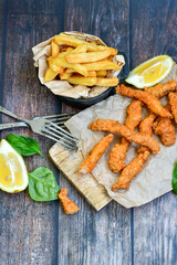 
 Crispy  deep fried home made    chicken strips Breaded  with  almond flour chicken  breast fillets  with chilly peppers and fresh   basil on wooden rustic background. Ketogenic diet food