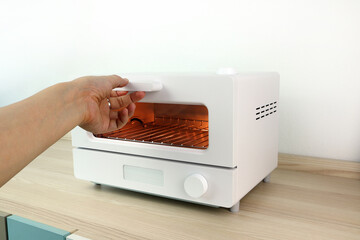 white modern design toaster oven is on the wooden table with white cement wall background in...