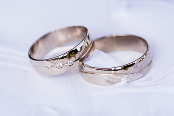 Real wedding rings made from white gold on a wedding background representing love ready for the bride and groom.