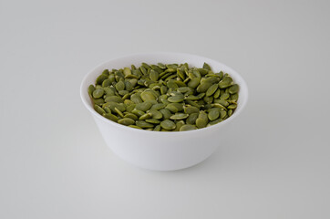 White plate with pumpkin seeds on a clean background. Proper nutrition.